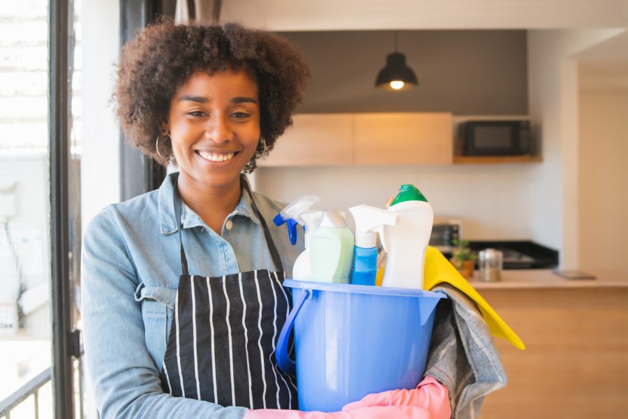 afro-woman-holding-bucket-with-cleaning-items